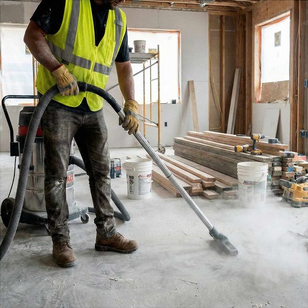 Reinigungskraft saugt Staub auf Baustelle - professionelle Baureinigung in Berlin